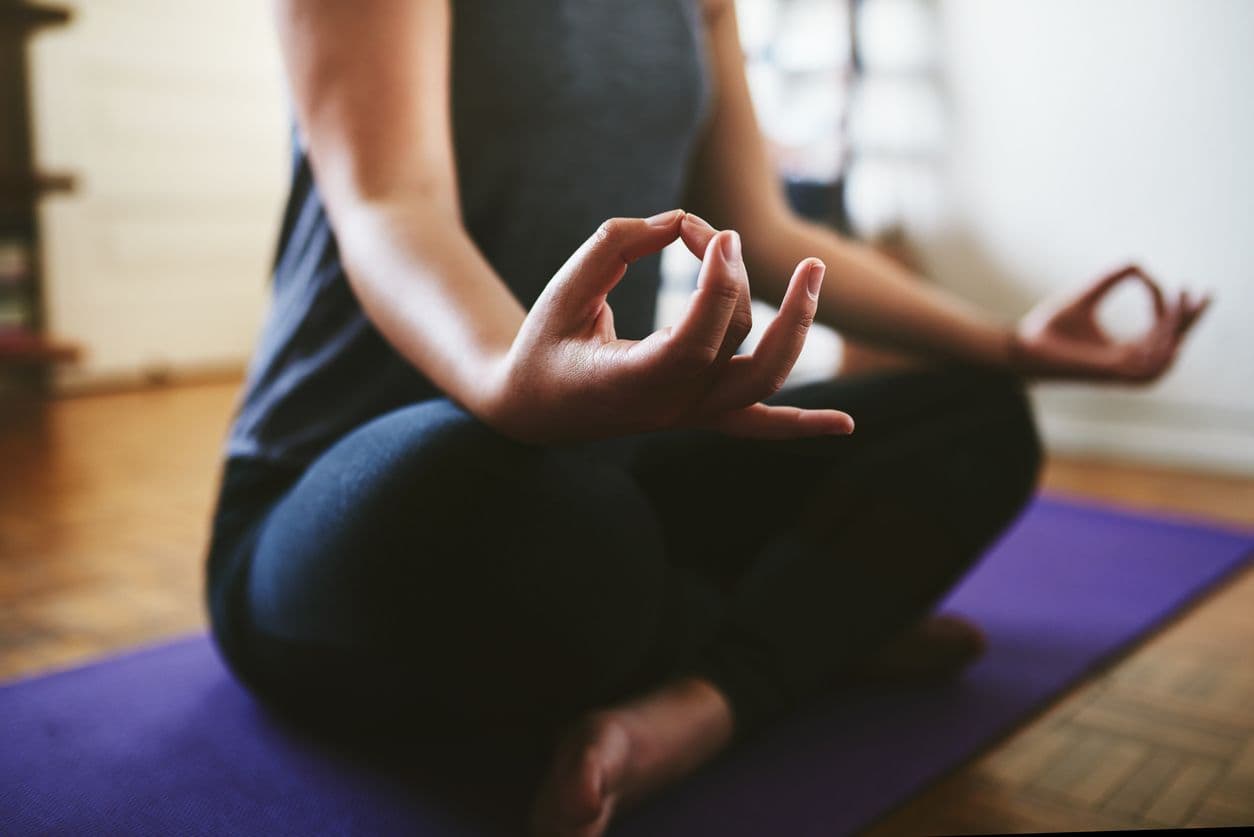 En person som sitter i yogaställning