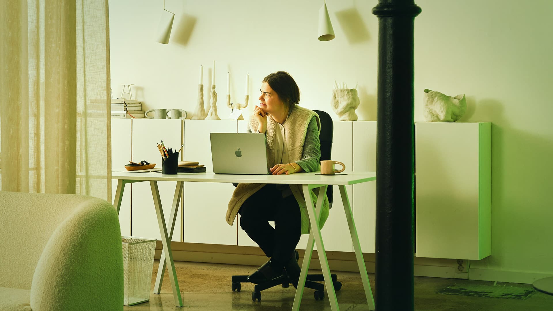 En person som sitter vid ett skrivbord och blickar ut