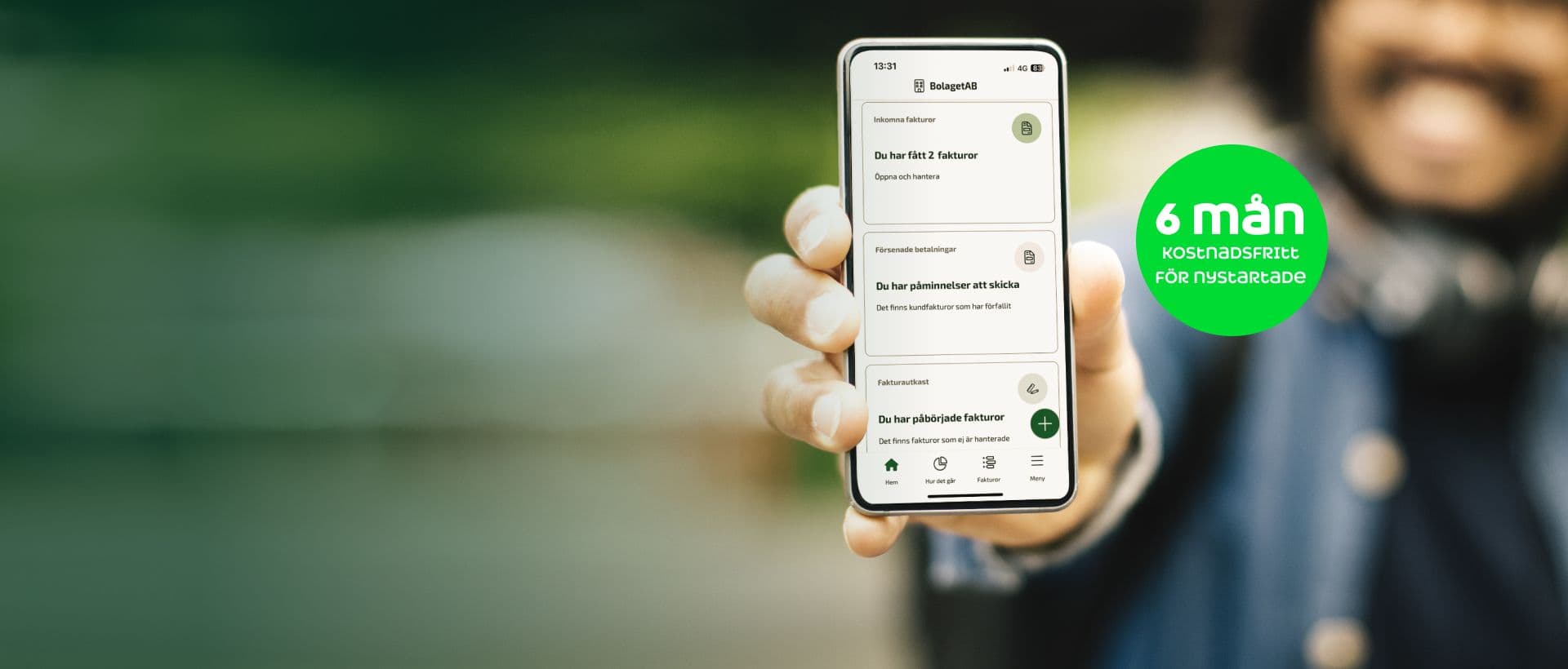 En person som håller fram en mobiltelefon med Fortnox App