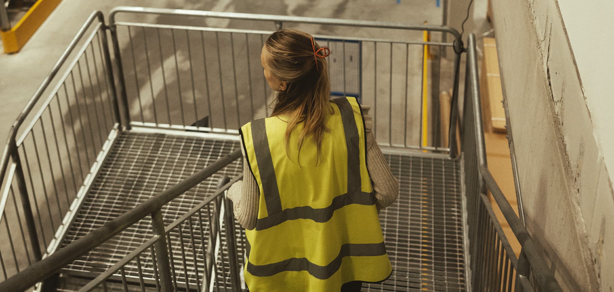 Kvinna med en reflexväst går i en trappa