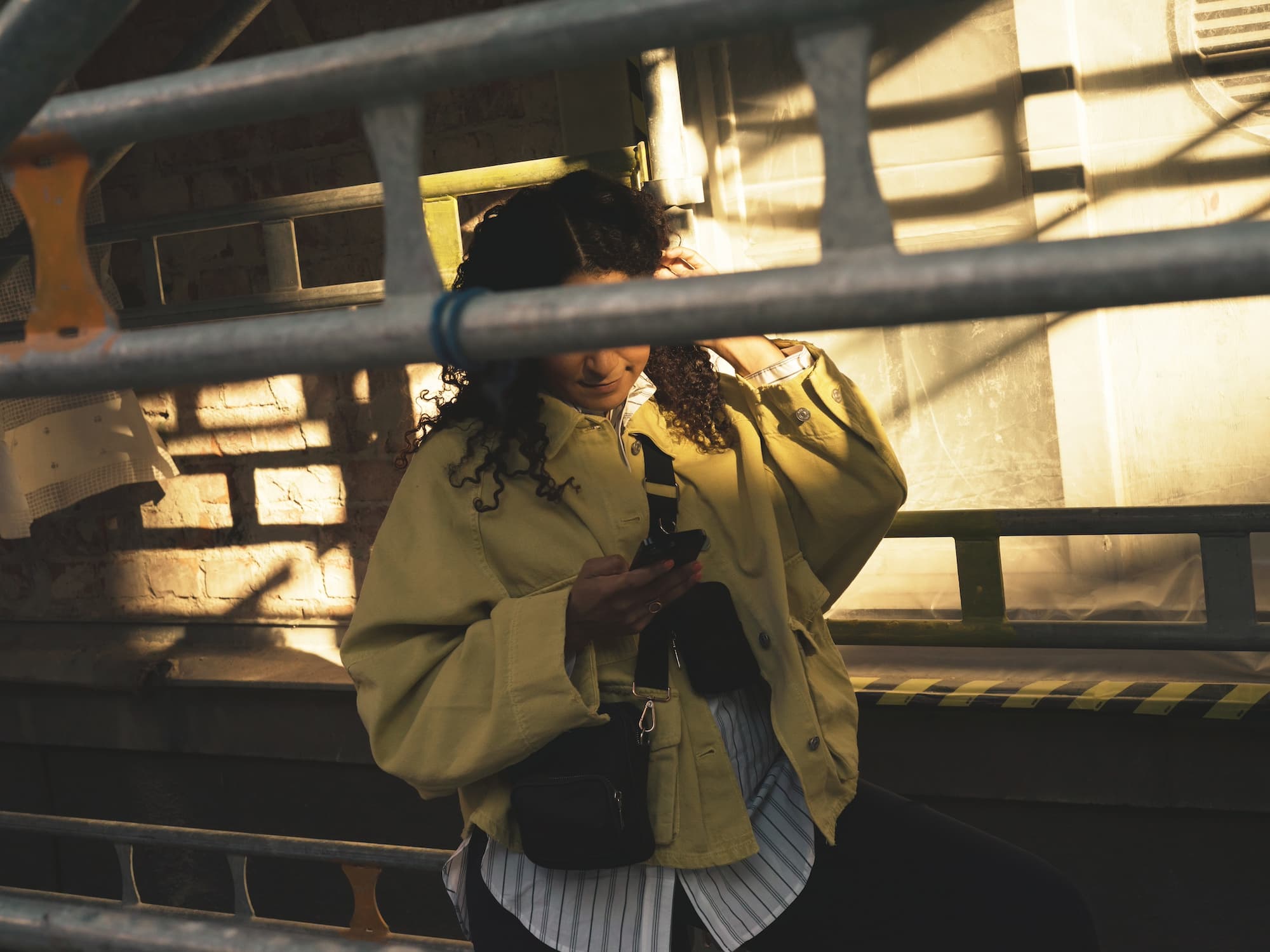 En kvinna som står och tittar på sin mobiltelefon