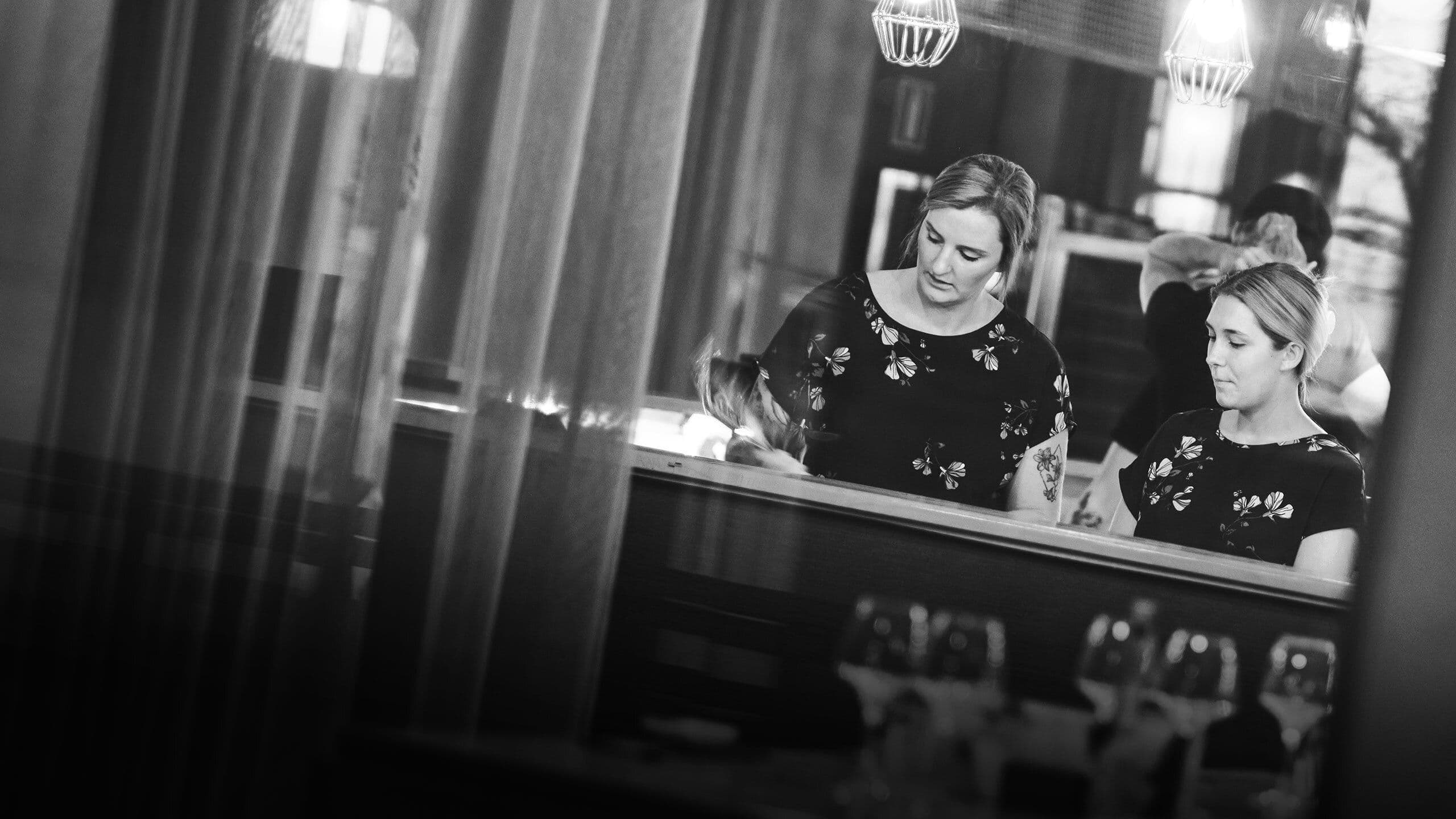Två personer som står vid kassan på en restaurang