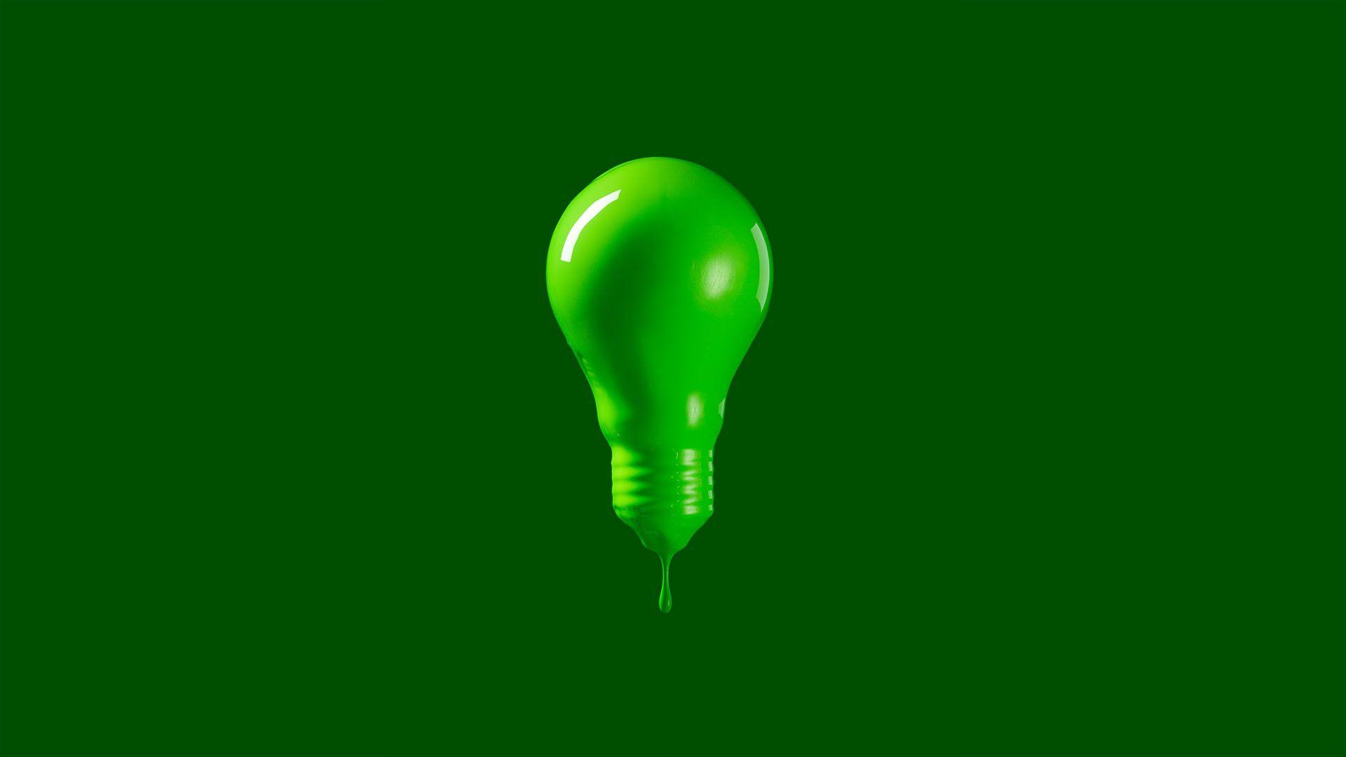 En glödlampa täckt av droppande grön färg 