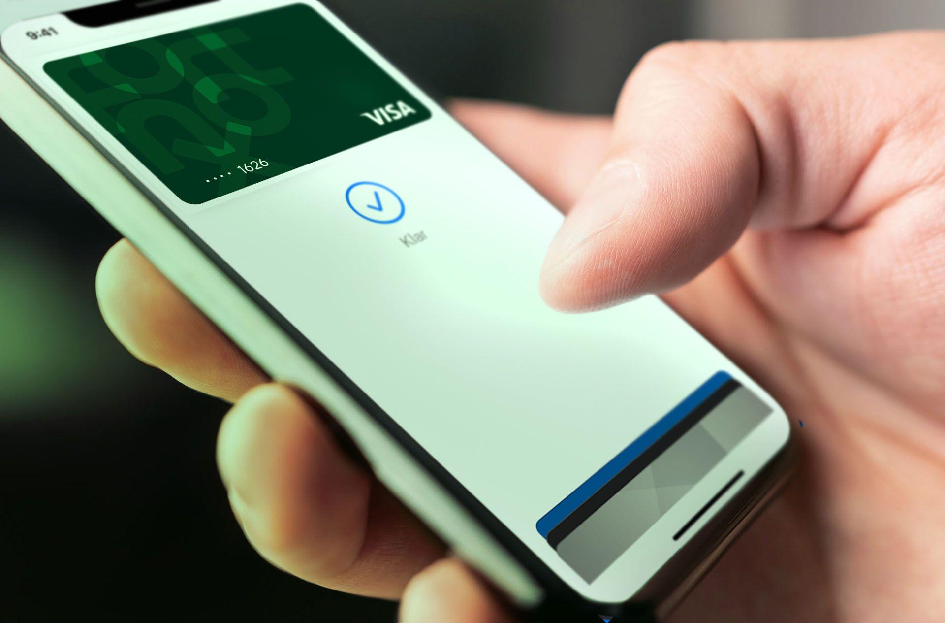 Person som genomför en betalning med Fortnox Kort i telefonen via Apple Pay.
