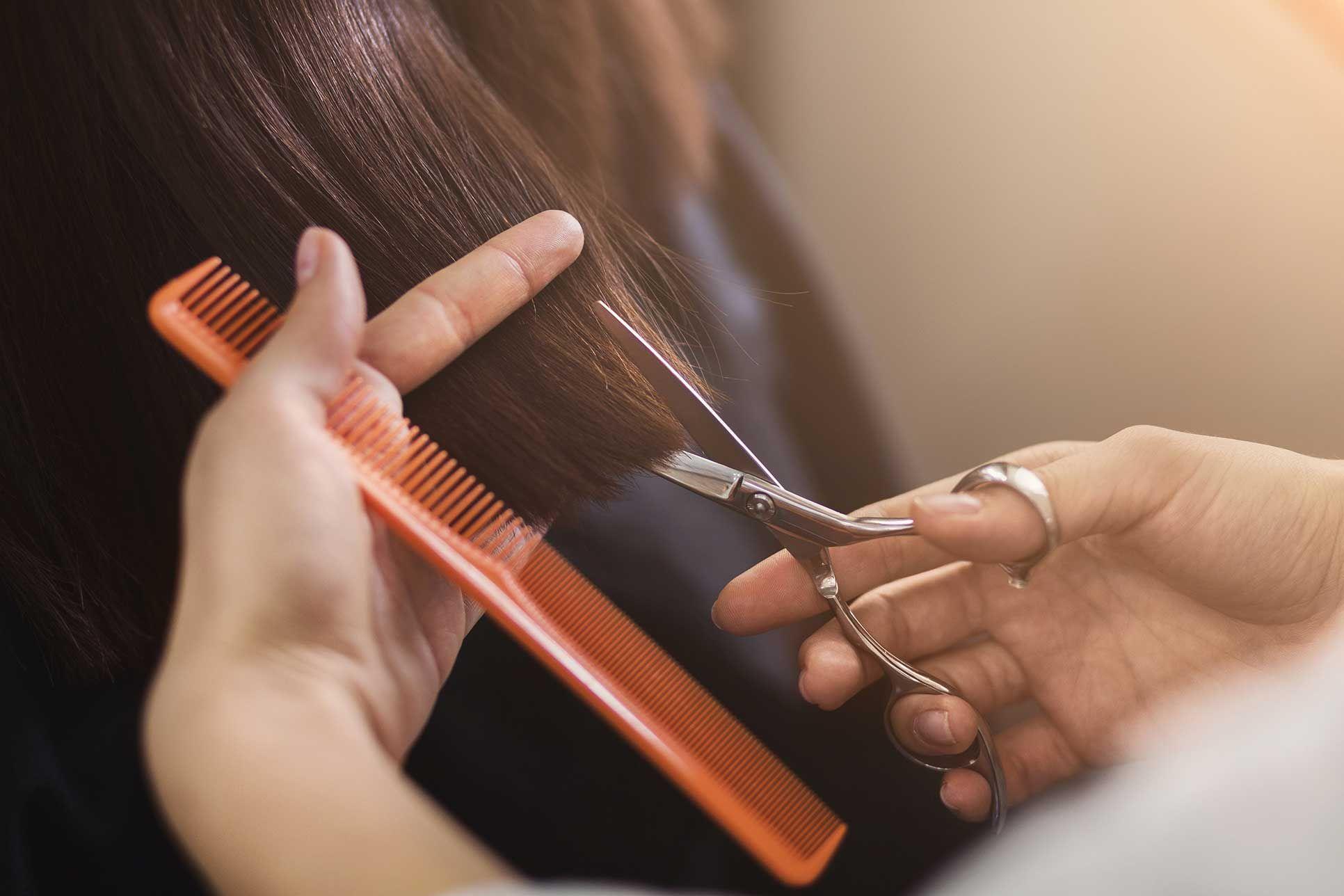 En frisör som klipper håret på en kund