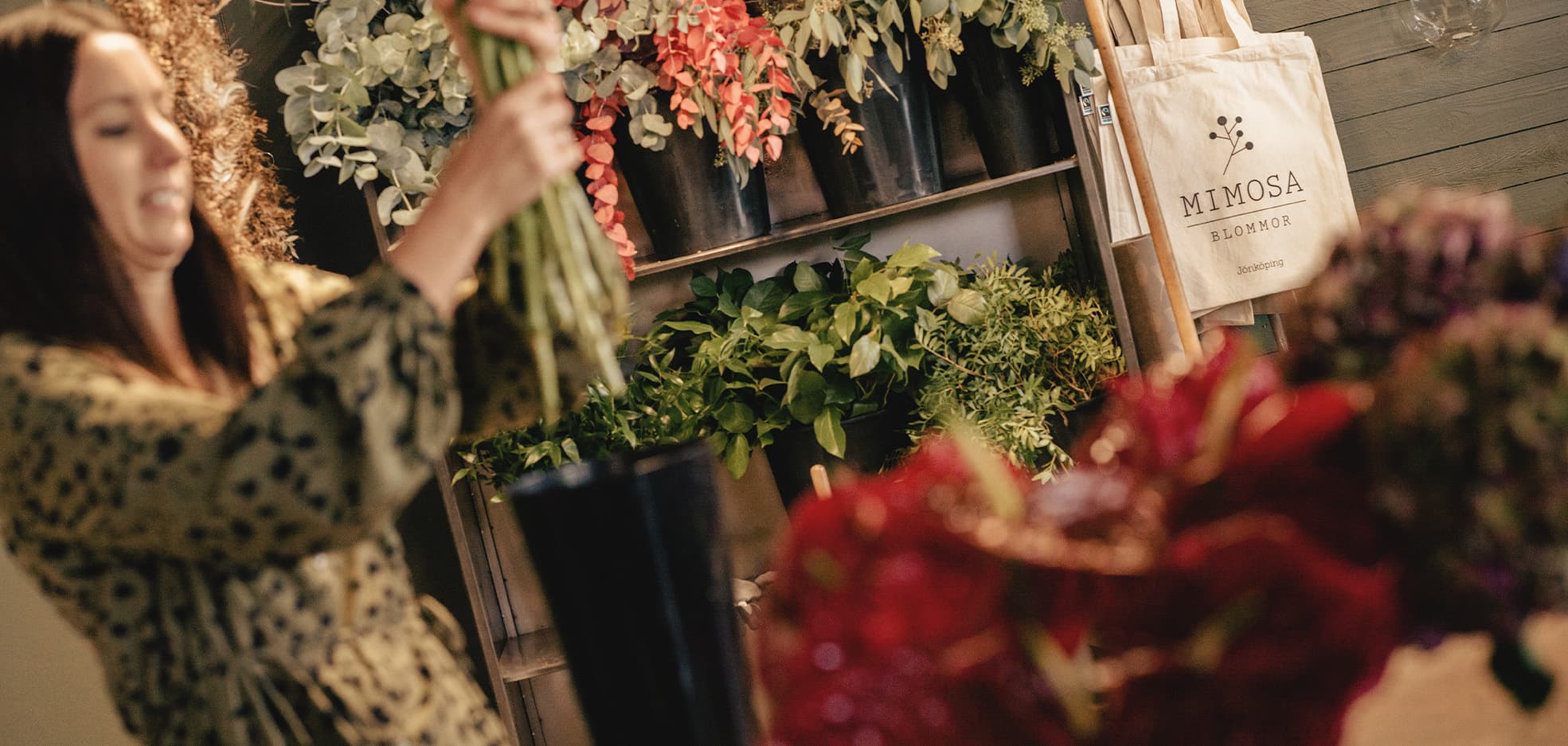 Kvinna fixar med blommorna i en butik